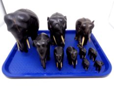 A tray containing eleven carved hardwood elephants