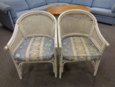 A pair of painted bamboo and wicker conservatory chairs