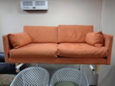 A two seater settee upholstered in a salmon fabric
