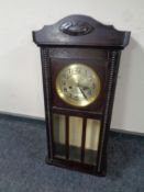 A 20th century wall clock with silvered dial and pendulum