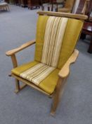 A 20th century beech framed rocking chair upholstered in a green striped fabric