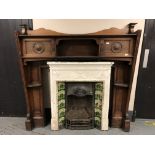 A Victorian cast iron tiled fire insert with carved oak surround,