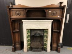 A Victorian cast iron tiled fire insert with carved oak surround,