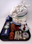 A tray containing chamber pot, table linen, cutlery, carved hardwood face masks,