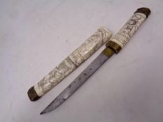 A carved brass and bone tanto dagger in sheath