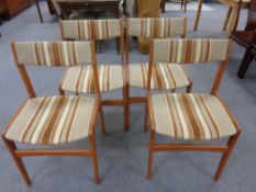 A set of four mid 20th century teak dining chairs upholstered in a striped fabric