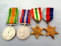 Four World War II medals on ribbons to include The War Medal, The Defence Medal,