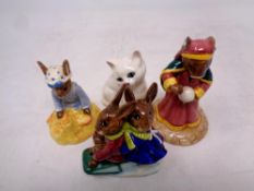 A Royal Doulton figure of a cat together with three further Royal Doulton Bunnykins figures