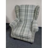 A wingback armchair upholstered in a checkered fabric