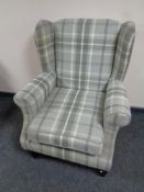 A wingback armchair upholstered in a checkered fabric