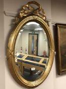 An antique oval gilt framed mirror,