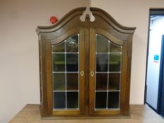 A 20th century double door wall cabinet with stained leaded glass doors