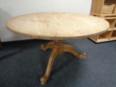 A circular pine farmhouse kitchen table on three way pedestal