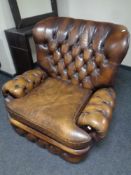 A Thomas Lloyd brown button leather manual reclining Chesterfield armchair