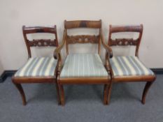 An antique mahogany scroll arm armchair together with two similar dining chairs