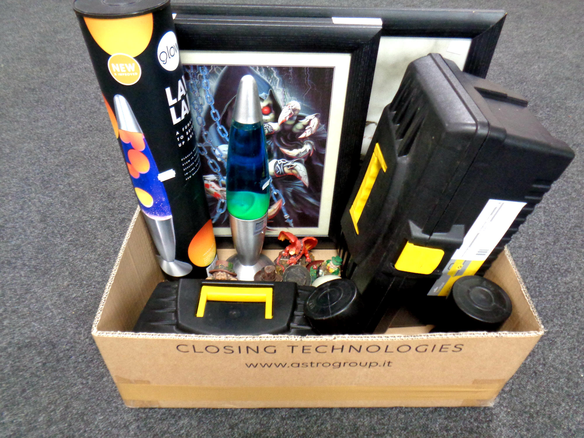 A box containing plastic toolboxes, framed pictures, ornaments,