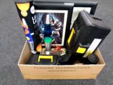 A box containing plastic toolboxes, framed pictures, ornaments,