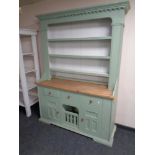 A painted pine welsh dresser fitted cupboards and drawers beneath