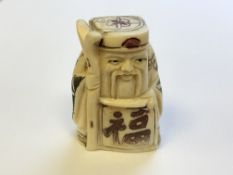 A Japanese carved bone netsuke - village elder holding a scroll