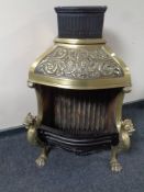 An ornate brass and cast iron fireplace on lion mask legs