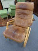A 20th century beech framed rocking chair upholstered in a tan leather