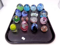 A tray containing sixteen assorted glass paperweights