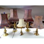 A pair of brass table lamps together with three further brass lamps,