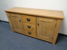A solid pine double door sideboard fitted three central drawers