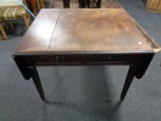 A 19th century mahogany flap sided table fitted two drawers on reeded legs