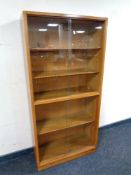 A twentieth century oak sliding glass door bookcase, width 69 cm.