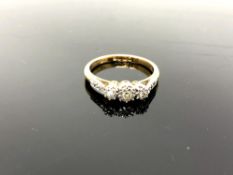 An 18ct yellow gold three stone diamond ring, set with diamond shoulders, size K/L, 3.1g.