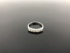 A platinum & diamond seven-stone half eternity ring, size K.