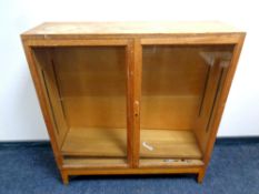 A mid century double door glazed bookcase on raised legs