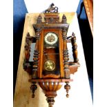 An antique Vienna wall clock with brass dial and pendulum