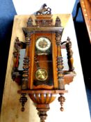 An antique Vienna wall clock with brass dial and pendulum