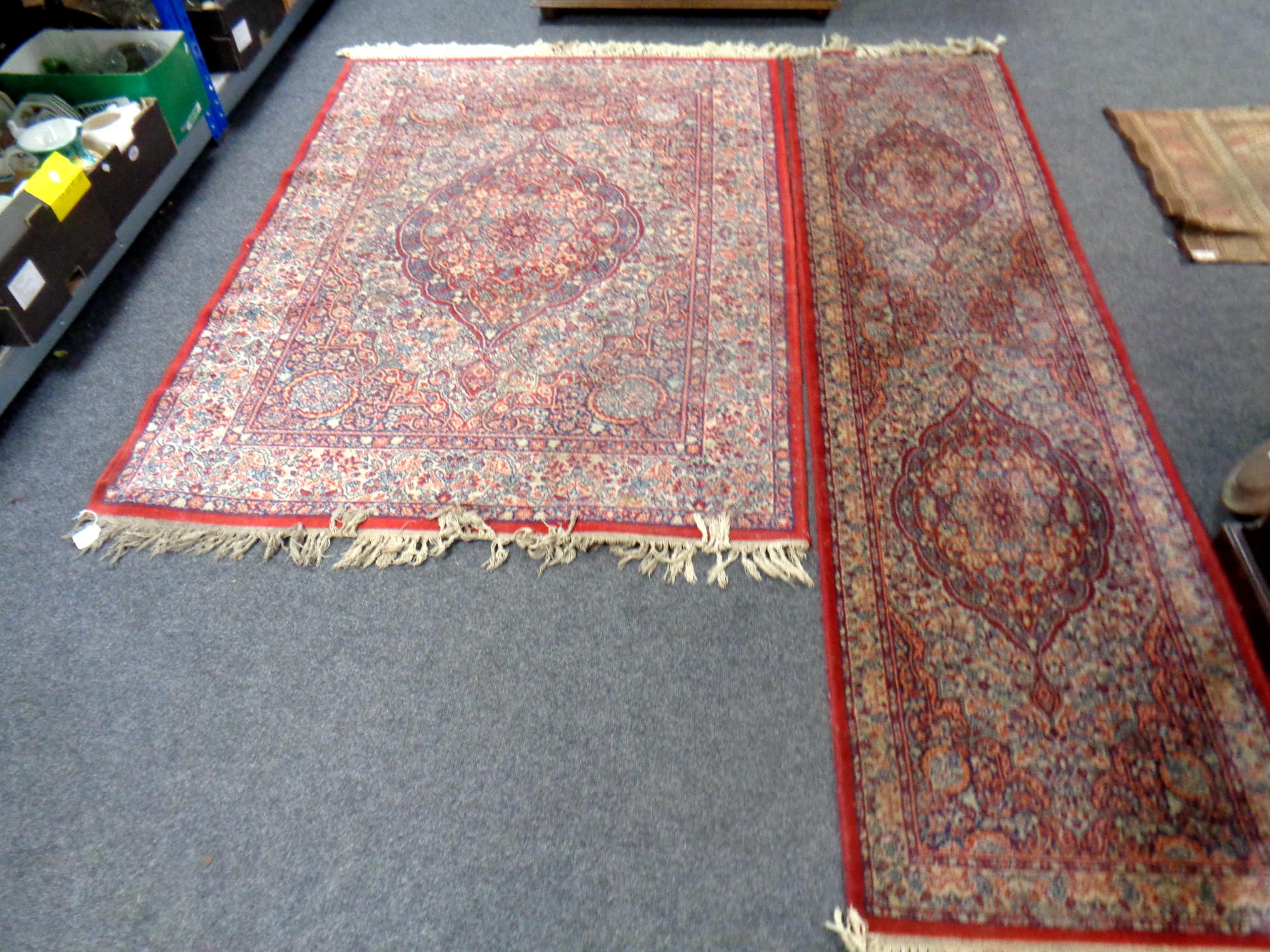 A machine made fringed woolen rug of Persian design together with similar carpet runner