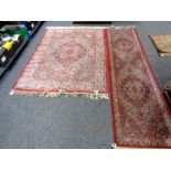 A machine made fringed woolen rug of Persian design together with similar carpet runner