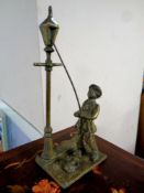 A brass figure of a lamp lighter with dog