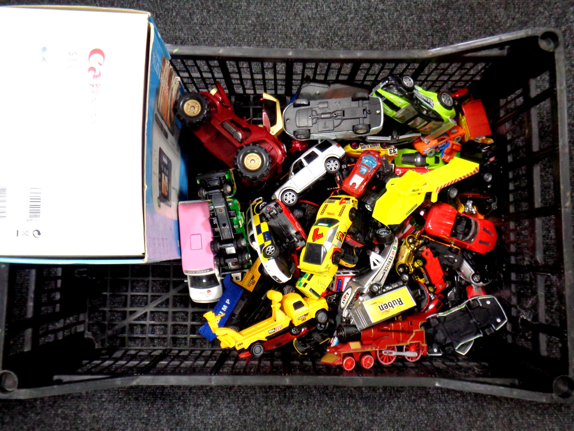A crate containing die cast vehicles, plastic train,