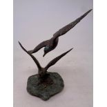 A bronze sculpture of two seagulls on slate base,