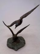 A bronze sculpture of two seagulls on slate base,