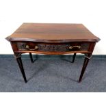 An Edwardian mahogany serpentine fronted side table fitted a drawer on reeded legs