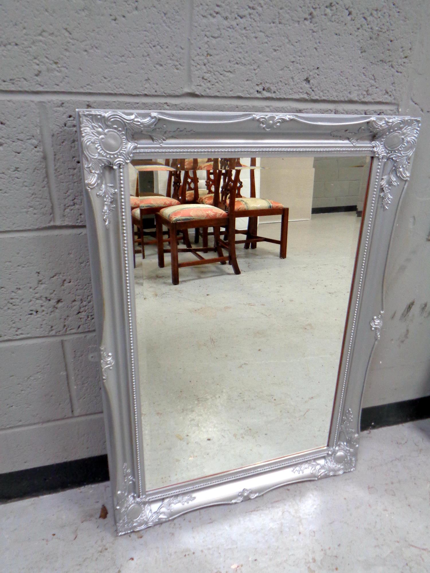 A contemporary silvered framed bevelled mirror