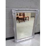 A contemporary silvered framed bevelled mirror