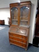 A twentieth century oak bureau bookcase with leaded glass doors