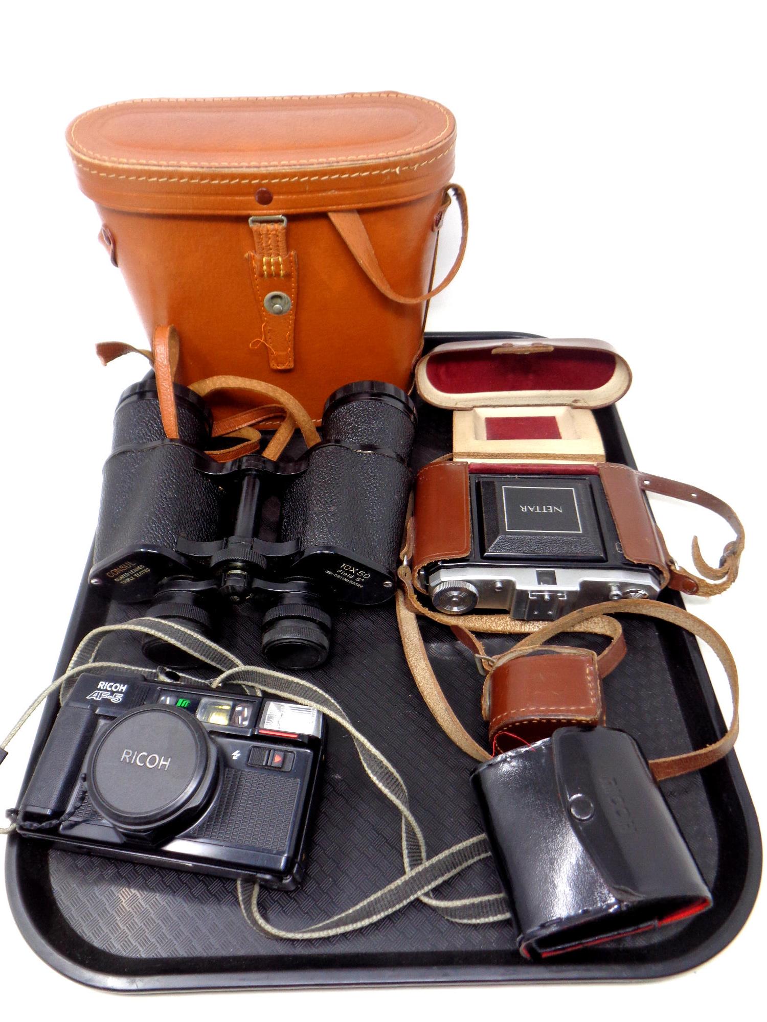A tray of leather cased field glasses together with cameras including Ricoh,