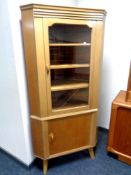 A twentieth century glazed door corner cabinet with cupboard below