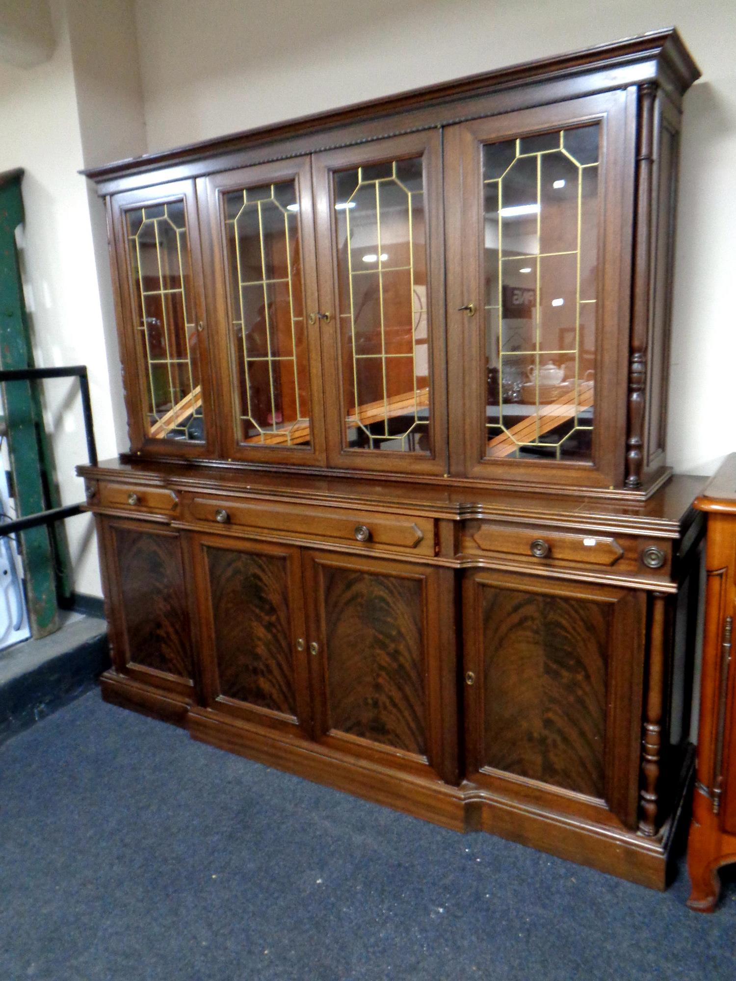 A Victorian style four door breakfronted sideboard fitted with three drawers with leaded glass