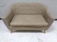 A contemporary buttoned two seater settee