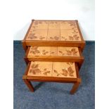 A nest of three twentieth century teak tiled tables